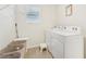 Well-lit laundry room equipped with a washer, dryer, storage bins, and wire rack shelving at 16946 Oval Rum Dr., Wimauma, FL 33598