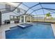 Backyard pool and spa in screened enclosure, barbecue and table with chairs on tiled patio at 16946 Oval Rum Dr., Wimauma, FL 33598