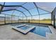Enclosed pool with spa and view of the yard and natural surroundings through screened enclosure at 16946 Oval Rum Dr., Wimauma, FL 33598