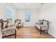 Cozy sitting room featuring hardwood floors and large windows that let in plenty of natural light at 16946 Oval Rum Dr., Wimauma, FL 33598