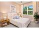 Cozy bedroom featuring a pastel color scheme, a window, and ample natural light at 17420 Moonflower Dr # 101, Venice, FL 34293