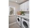 Functional laundry room with white cabinets, countertop, and modern appliances at 17420 Moonflower Dr # 101, Venice, FL 34293