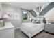 Cozy bedroom boasting artistic wall decor, neutral tones, hardwood flooring and large window at 17420 Moonflower Dr # 102, Venice, FL 34293