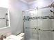 Updated bathroom featuring a tiled shower with glass doors and a stylish accent stripe at 2022 Camelot Dr # 9, Clearwater, FL 33763