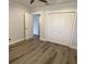 Neutral bedroom with closet and wood-look floors, freshly painted walls, and bright trim at 2022 Camelot Dr # 9, Clearwater, FL 33763