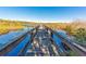 Wooden dock extending into a tranquil lake surrounded by natural vegetation at 2022 Camelot Dr # 9, Clearwater, FL 33763