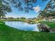 Scenic pond with gazebo and a dock, surrounded by lush green grass and mature trees at 2022 Camelot Dr # 9, Clearwater, FL 33763