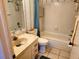 Traditional bathroom featuring a tiled shower-tub, sink vanity, and decorative wallpaper design at 205 Dogwood Cir # 205, Seminole, FL 33777
