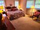 Spacious primary bedroom with floral bedding, ample lighting, and a classic chair at 205 Dogwood Cir # 205, Seminole, FL 33777