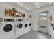 Clean laundry room with multiple machines and shelving at 205 Dogwood Cir # 205, Seminole, FL 33777