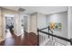 Hallway with railing and colorful painting leads to various rooms with hardwood floors at 220 2Nd Sw Ave, Largo, FL 33770