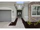 Close-up of the home's entry way featuring the gray brick facade and walkway to the front door at 24041 Peppercorn Rd, Punta Gorda, FL 33955