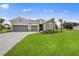 Well-maintained single-story home featuring a two-car garage, stone accents, and vibrant landscaping at 24041 Peppercorn Rd, Punta Gorda, FL 33955