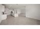 Open living room area with tile flooring, bright kitchen with island, and stainless steel appliances at 24041 Peppercorn Rd, Punta Gorda, FL 33955