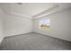 Main bedroom featuring carpeted floor, tray ceiling, and window view at 24041 Peppercorn Rd, Punta Gorda, FL 33955