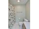 This bathroom has a toilet, a shower with a curtain with a fun pattern, and a towel rack at 312 Fairside Ct # 12, Sun City Center, FL 33573