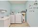 Bright laundry room includes new washer, dryer, and water heater on tile floor at 312 Fairside Ct # 12, Sun City Center, FL 33573