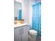 Charming bathroom featuring a bright blue shower curtain, toilet, and modern vanity, adding a splash of color to the space at 32768 Tree Of Life Ave, Wesley Chapel, FL 33543