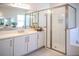 Bright bathroom with a double sink vanity and a glass-enclosed shower, featuring modern fixtures and finishes at 32768 Tree Of Life Ave, Wesley Chapel, FL 33543