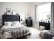 Bright bedroom with a black upholstered headboard bed, grey throw blanket, and black dressers at 32768 Tree Of Life Ave, Wesley Chapel, FL 33543