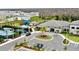 Aerial view of clubhouse, tennis courts, playground, and parking with tropical landscaping at 32768 Tree Of Life Ave, Wesley Chapel, FL 33543