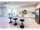 Open kitchen with an island, stainless steel appliances, modern white cabinets, and access to the dining area at 32768 Tree Of Life Ave, Wesley Chapel, FL 33543