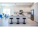 Modern kitchen with a large island, stainless steel appliances, sleek white cabinets, and a dining area nearby at 32768 Tree Of Life Ave, Wesley Chapel, FL 33543