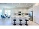Well-lit kitchen featuring a central island with bar seating, stainless steel appliances, and an adjacent dining space at 32768 Tree Of Life Ave, Wesley Chapel, FL 33543