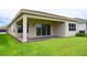 Covered patio with green lawn and sliding glass doors at 32768 Tree Of Life Ave, Wesley Chapel, FL 33543