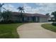 Charming single-story home featuring a red tile roof, a spacious driveway, and tropical landscaping at 3936 48Th S Ave, St Petersburg, FL 33711