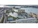 Wide aerial view showcasing a waterfront condo community with a pond, pool, and tennis courts at 4550 Cove Cir # 407, St Petersburg, FL 33708