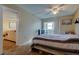 Bedroom with ceiling fan, striped comforter and view into the living room at 4550 Cove Cir # 407, St Petersburg, FL 33708