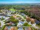 Aerial view of homes in the neighborhood, showing mature trees, landscaping, a golf course, and ponds at 4859 Augusta Ave, Oldsmar, FL 34677