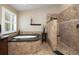 Bright bathroom featuring a tub and a shower with mosaic tile, as well as large windows at 4859 Augusta Ave, Oldsmar, FL 34677