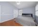 Comfortable bedroom featuring hardwood floors, a queen bed, and a bright window at 4859 Augusta Ave, Oldsmar, FL 34677