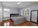 Bright bedroom with hardwood floors, plantation shutters, queen bed, and a large mirror at 4859 Augusta Ave, Oldsmar, FL 34677