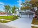 Charming two-story home with a well-manicured lawn, mature trees, a spacious driveway, and a three-car garage at 4859 Augusta Ave, Oldsmar, FL 34677