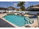 Beautiful backyard pool area complete with lounge chairs, umbrellas, and travertine decking at 4859 Augusta Ave, Oldsmar, FL 34677
