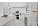 Bright kitchen showcasing stainless steel appliances, white cabinets and a large island at 5014 Coastal Oak Ct, Lakewood Ranch, FL 34211