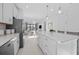 Open concept kitchen featuring white cabinetry, a kitchen island with barstools, and stainless steel appliances at 5014 Coastal Oak Ct, Lakewood Ranch, FL 34211