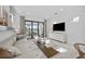 Open-concept living room with a modern sofa, glass coffee table, and a view of the lake through sliding glass doors at 5014 Coastal Oak Ct, Lakewood Ranch, FL 34211