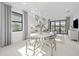 Cozy dining room features a table with seating for four, modern light fixture, and sliding glass doors to the patio at 5014 Coastal Oak Ct, Lakewood Ranch, FL 34211