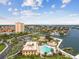 Spectacular aerial view highlighting a large pool, waterfront, shuffleboard court, and manicured greenery at 5200 Brittany Dr. S # 706, St Petersburg, FL 33715
