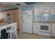Well-lit kitchen boasting white appliances and cabinets, complemented by tile flooring at 5200 Brittany Dr. S # 706, St Petersburg, FL 33715