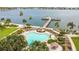 Aerial view of the community pool, chairs and tiki hut. Beautiful landscaping and water views in the background at 5200 Brittany Dr. S # 706, St Petersburg, FL 33715