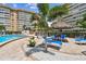 Inviting pool area featuring comfortable lounge chairs, lush greenery, and a relaxing poolside tiki umbrella at 5200 Brittany Dr. S # 706, St Petersburg, FL 33715