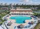 Aerial view of community pool, tiki huts and lounge chairs with building, palms and landscaping at 5200 Brittany Dr. S # 706, St Petersburg, FL 33715