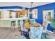 Chic dining area with blue accent wall and view to kitchen, seats four beneath modern chandelier at 5277 Isla Key S Blvd # 422, St Petersburg, FL 33715