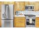 Close-up of kitchen area with stainless steel appliances, wood cabinets, and granite countertops at 5277 Isla Key S Blvd # 422, St Petersburg, FL 33715
