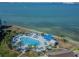 Aerial view of a waterfront community pool with lounge chairs and clear blue umbrellas at 5277 Isla Key S Blvd # 422, St Petersburg, FL 33715